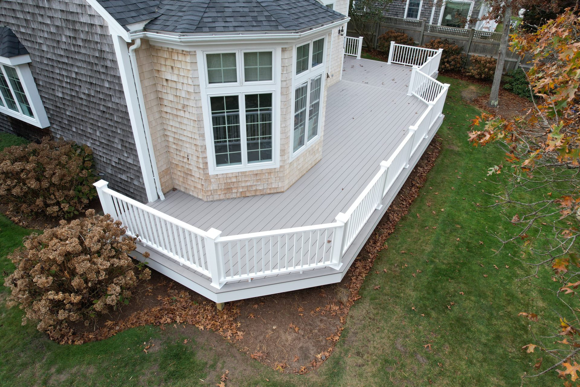 Wraparound cedar deck with cable railings — HyTech Roofing, Cape Cod